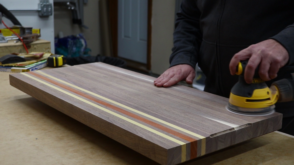 Lightly sanding the board to knock down any grain