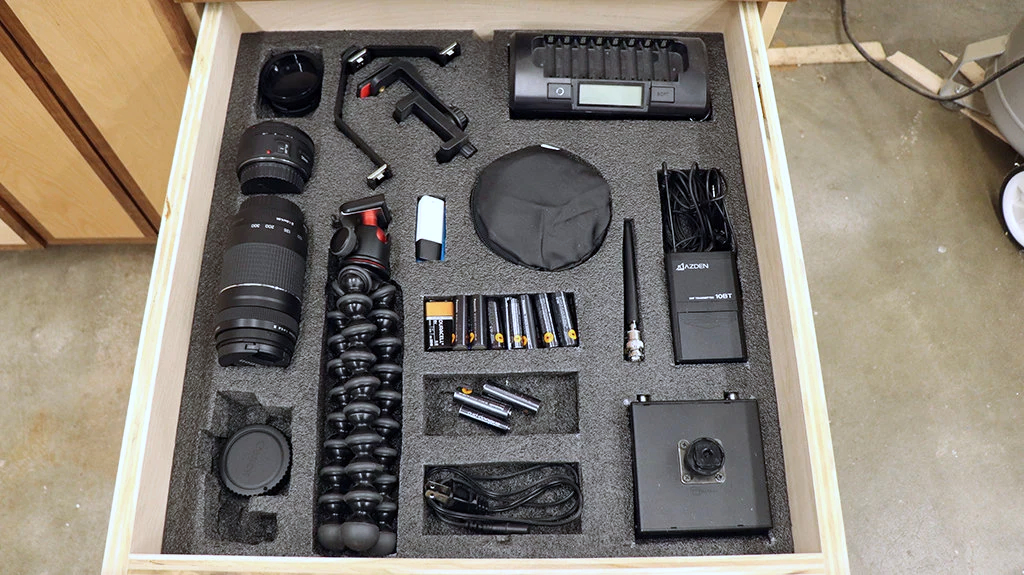 Camera gear organized in a shop storage base cabinet drawer