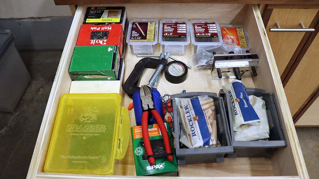 Hardware organized in a shop storage base cabinet drawer
