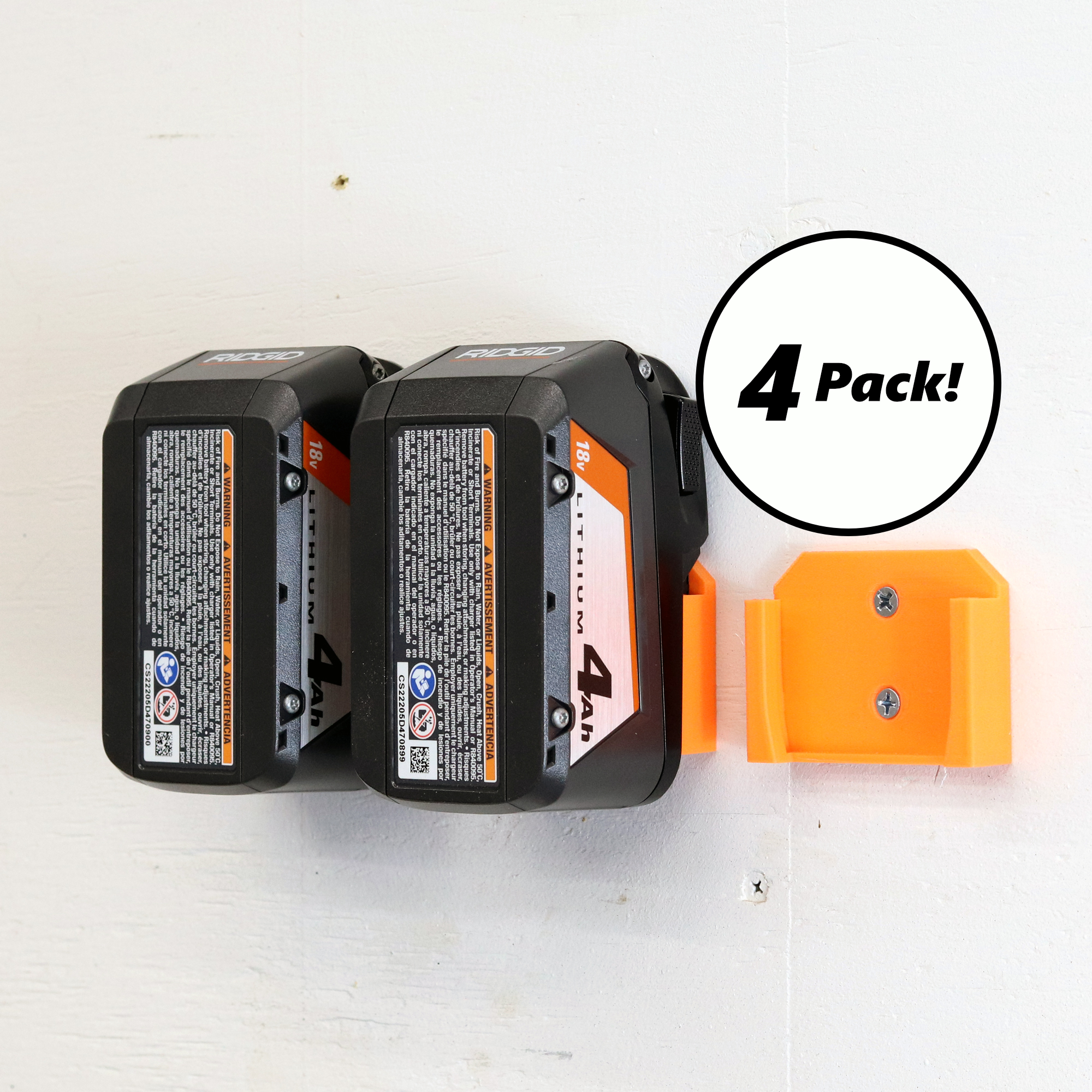 Four Ridgid battery holders mounted on a wall, each holding a 18V battery