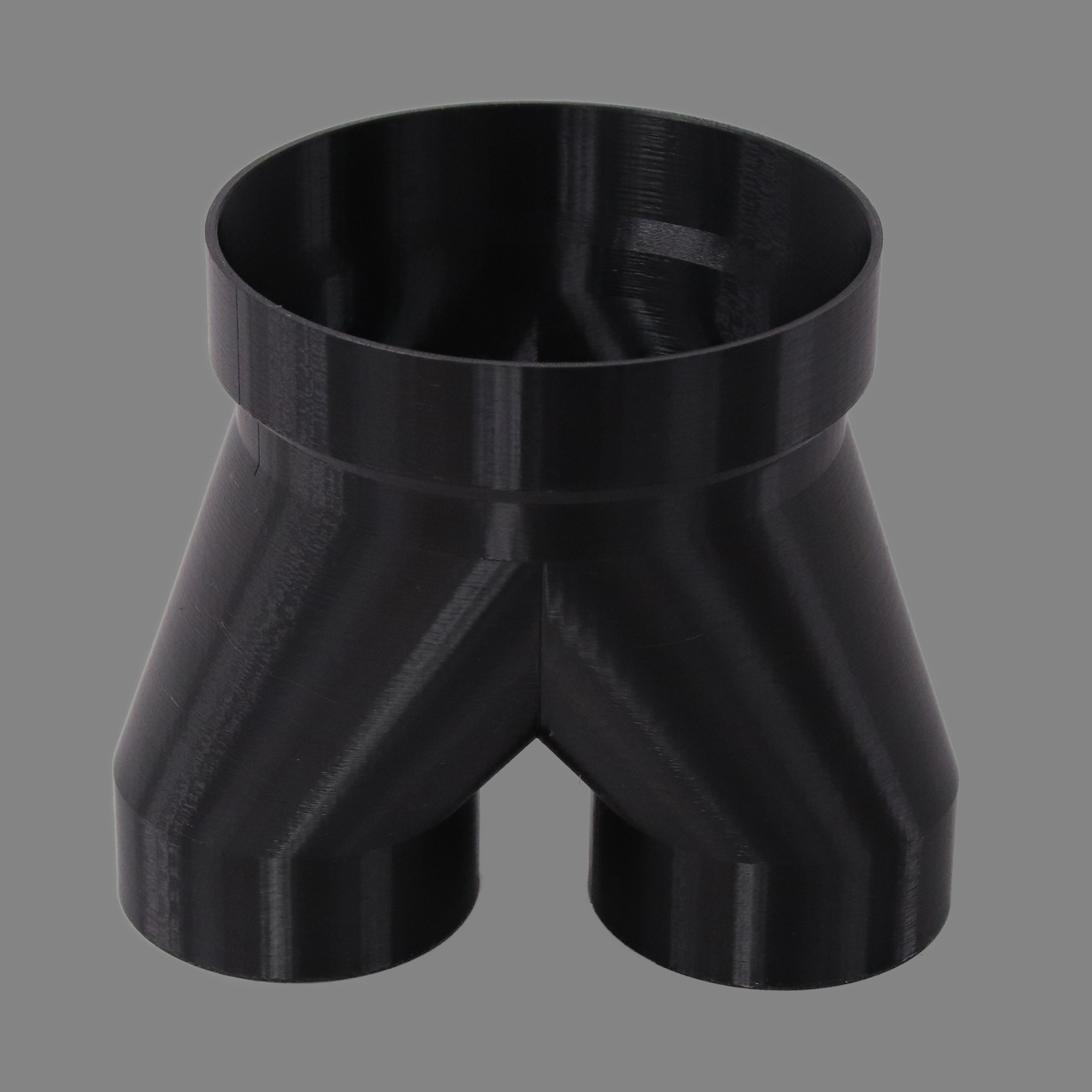 Black 3D printed PETG dust collection adapter connecting 6 inch SDR35 PVC to dual 4 inch flex hose outlets, alternate angle product photo