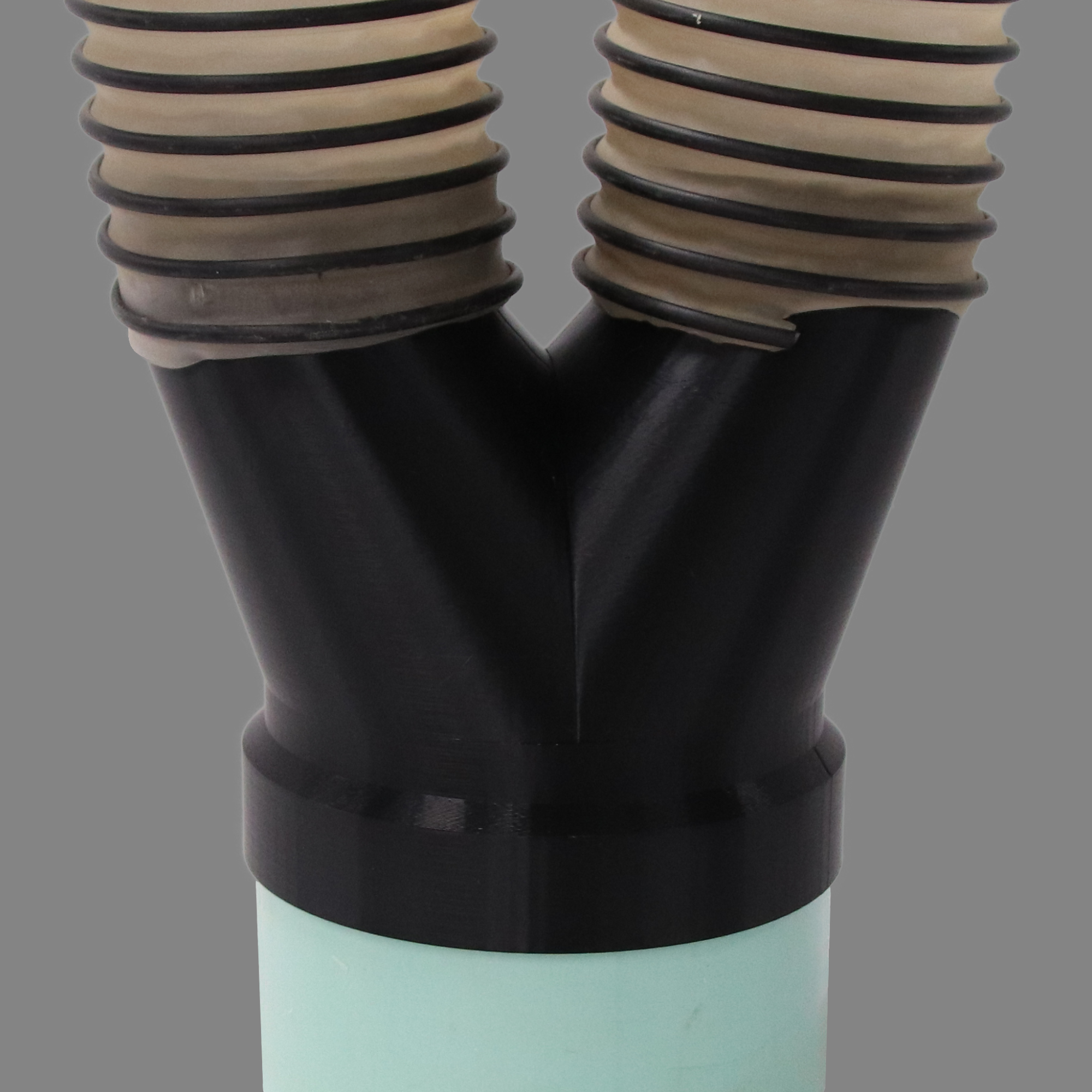 Black PETG dust collection adapter connecting 6 inch SDR35 PVC to dual 4 inch flex hose outlets, shown installed in a shop dust collection hose line