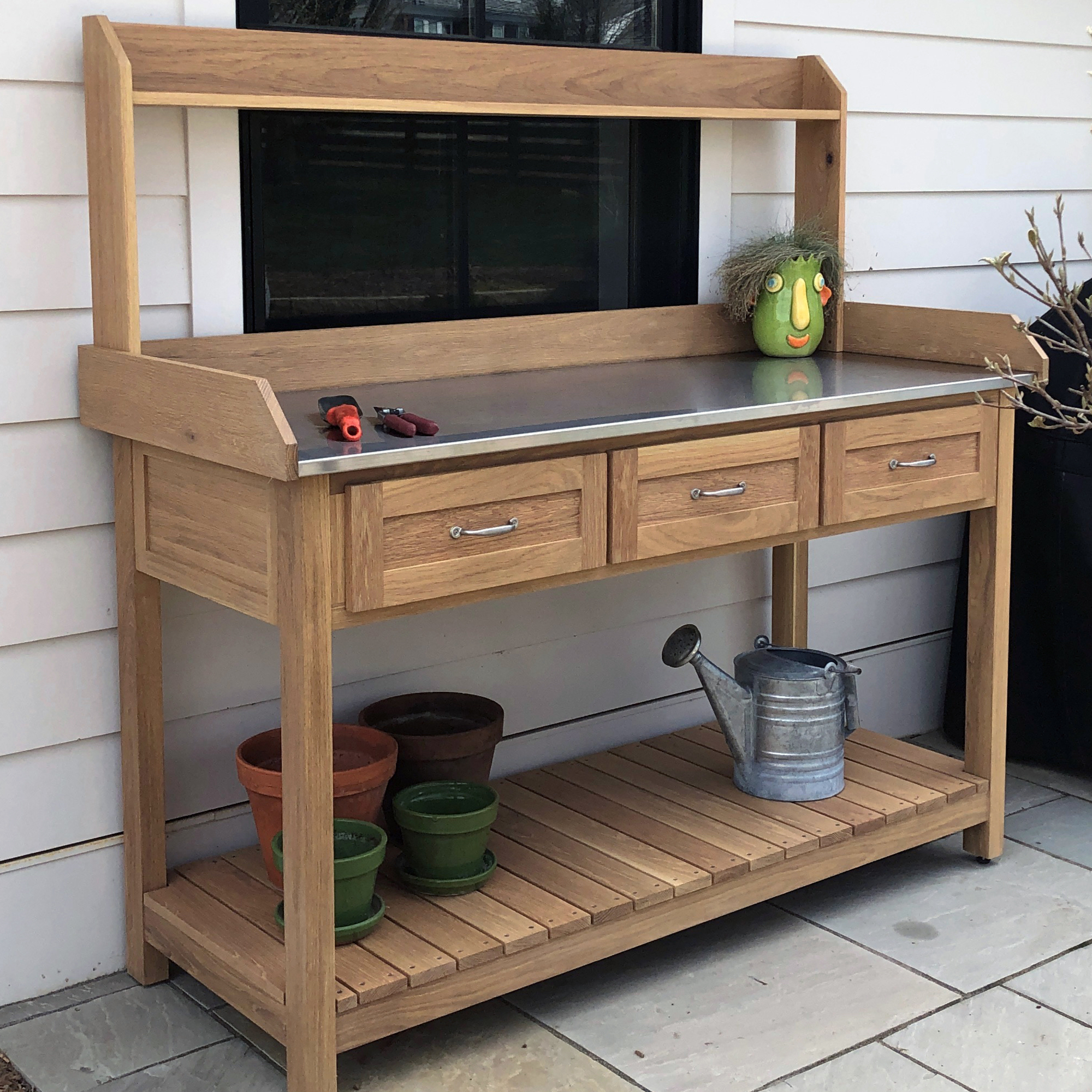 Front view of a DIY potting bench with three drawers and a hutch