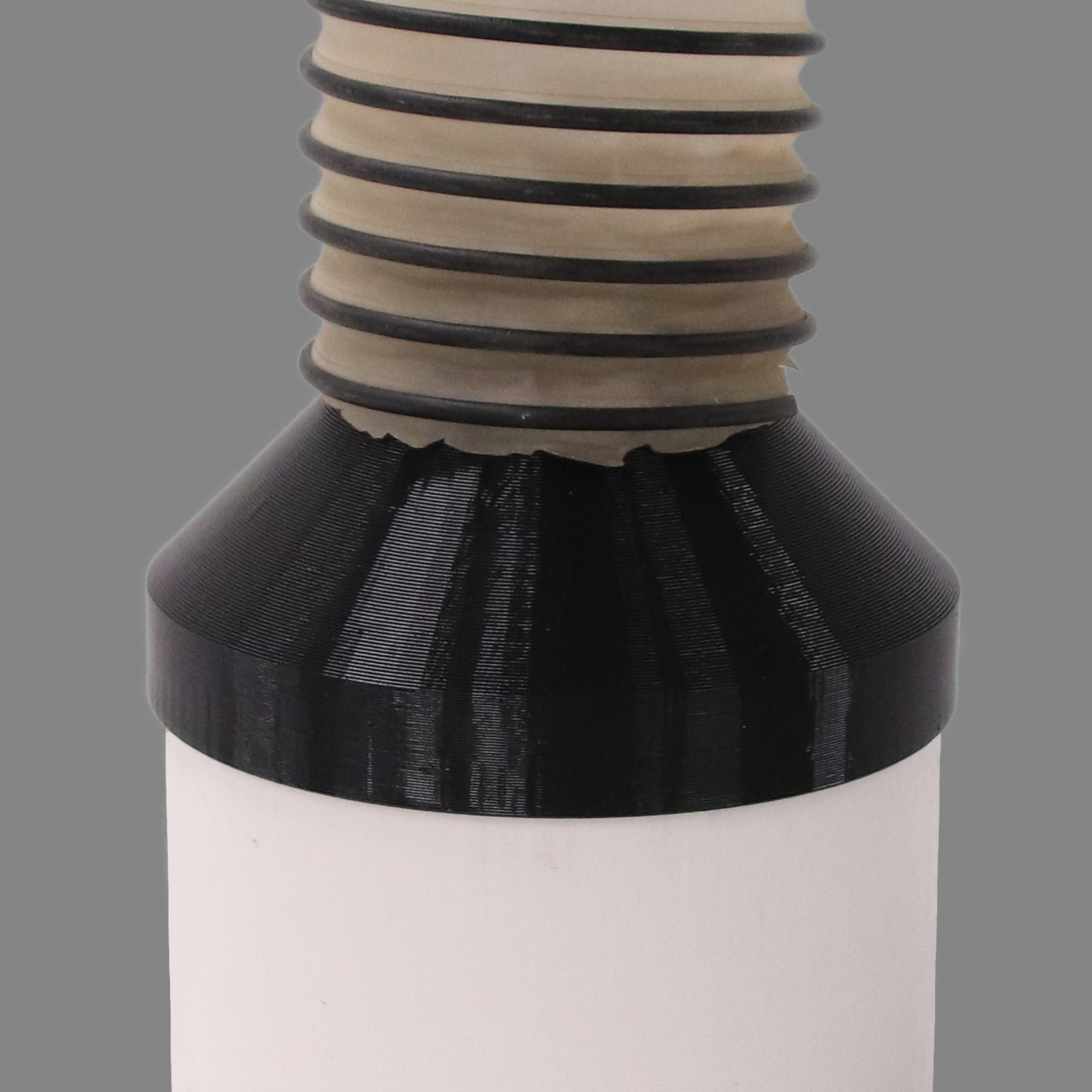 Black PETG dust collection adapter connecting 6 inch SCH40 PVC to 4 inch flex hose, shown installed in a shop dust collection hose line