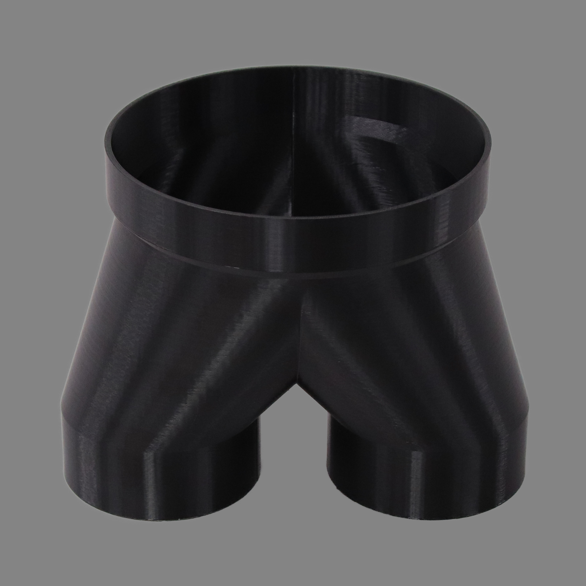 Black 3D printed PETG dust collection adapter connecting 6 inch SCH40 PVC to dual 4 inch flex hose outlets, alternate angle product photo